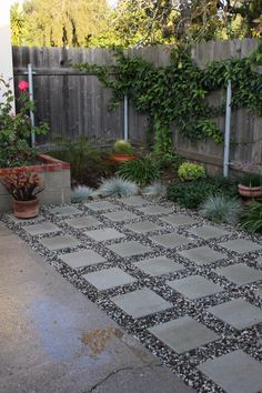 an outdoor patio with potted plants on the side and concrete pavers flooring