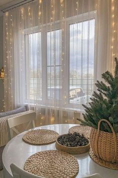 a living room filled with furniture and a christmas tree on top of a white table