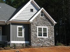 a gray and white house in the woods