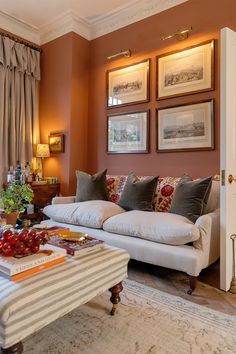 a living room filled with furniture and pictures on the wall above it's coffee table