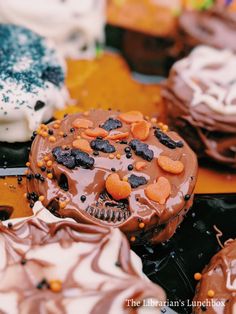 there are many different types of cakes on the table with frosting and sprinkles