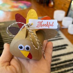 a hand holding a paper bag with a turkey on it and a tag that says, thank you