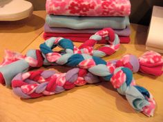 several different colored pieces of fabric on a wooden table with one knot tied to the other