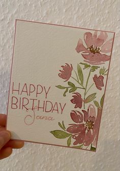 a hand holding up a card with flowers on it that says happy birthday janea