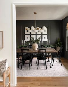 a dining room with black walls and wooden floors