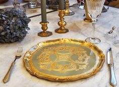 a table set with silver and gold place settings