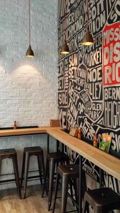 the interior of a restaurant with black and white wallpaper, wooden tables and stools