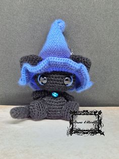 a small crocheted stuffed animal with a blue hat on it's head