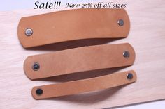 two leather knife sheaths are sitting on a wooden table with the price tag sale now 55 % off all sizes