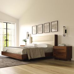 a bedroom with white walls and wooden floors