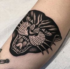 a black and white tattoo on the arm of a person with a tiger head design