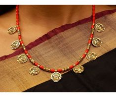 Product Description :  High quality Oxidized Gold Goddess Durga Coins with Red Coral beads Necklace with adjustable necklace dori for perfect fitting. A perfect choice for your jewellery collection. Suitable for Wedding, ethnic wear, festive and party wear. A beautiful gift for your loved ones. This product is especially handmade for you after receiving the order and takes 4 to 5 man hours to complete, hence slight imperfections are expected which is not a defect.  Slight color variation of the product may occur due to photographic light effect. Necklace Weight : 55 gms Dimensions : Necklace Length (w/o dori) - 22 cm, Dori Length - 26 cm Material : Alloy metal, Oxidized Gold, Faux Coral beads Product Care :  Avoid contact with body spray, chemicals & water. Clean with soft cloth after use Red Temple Jewelry Necklace For Diwali, Festive Red Temple Jewelry Necklaces, Red Necklaces With Latkans For Diwali, Red Temple Necklace With Latkans For Gifts, Festive Red Necklace With Latkans, Red Jewelry For Navratri Puja, Red Necklaces For Puja And Diwali, Red Necklaces For Diwali Puja, Red Round Beads Necklace For Ceremonial Occasions