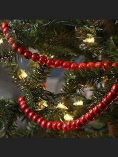 a christmas tree with red beads hanging from it's branches