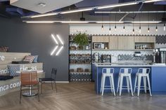 an open concept kitchen and dining area with bar stools in the foreground, wood flooring on the other side