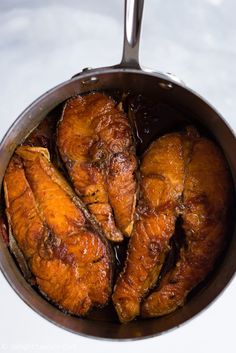 some chicken is cooking in a pot on the stove