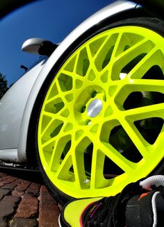 a close up of a car tire with bright yellow spokes on it's rim