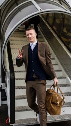 a man in a suit and tie is walking down an escalator with his handbag