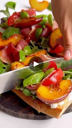 someone is cutting up some food on top of a wooden platter with a knife