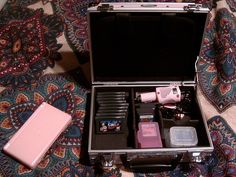 an open suitcase sitting on top of a carpet next to a pink object in it