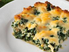 a piece of quiche with cheese and spinach on a white plate