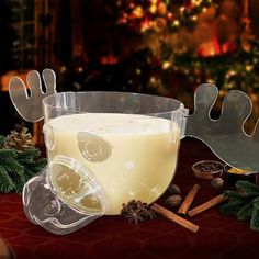 a glass filled with liquid sitting on top of a table next to some christmas decorations