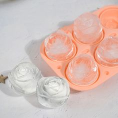 an ice tray with six cups in it next to a flower shaped cookie molder