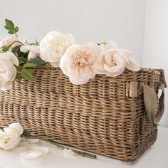 a wicker basket filled with flowers on top of a table