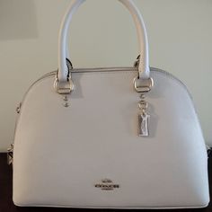 The Coach Katy Satchel Is A Cute And Elegant Handbag In The Cross-Grain Leather. It Features An Inside Zip Pocket, Zip Closure, Outside Zip Pocket And Fabric Lining. Four Protective Feet At Base. It's The Perfect Size And So Lightweight! Handles With 3 3/4" Drop Detachable Strap With 22" Drop For Shoulder Or Crossbody Wear 11 3/4" (L) X 7 3/4" (H) X 4" (W) Elegant Coach Satchel With Zipper Closure, Coach Sierra, Elegant Handbag, Coach Satchel, Coach Legacy, Leather Satchel Handbags, Leather Saddle Bags, Bags Coach, Satchel Handbags