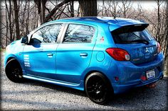 a blue car parked in front of some trees