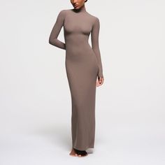 The SKIMS Soft Lounge Turtleneck Long Dress features a chic turtleneck and a full-length design. Crafted from a slinky ribbed fabric, the dress is designed to provide a flattering hourglass silhouette. It fits true to size and is available in sizes XXS-XL and 2X-4X. The dress measures 56 1/2 inches in length for sizes XXS-XL and 58 inches in length for sizes 2X-4X. Hourglass Silhouette, Closet Needs, Mock Neck Long Sleeve, Sleeve Maxi Dress, Long Sleeve Maxi, Ribbed Fabric, Long Sleeve Maxi Dress, Stylish Dresses, Mock Neck