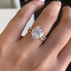 a woman's hand with a diamond ring on her finger and an engagement band