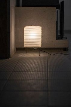 a lamp sitting on top of a floor next to a wall