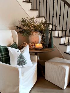 a living room filled with furniture next to a stair case covered in christmas tree pillows