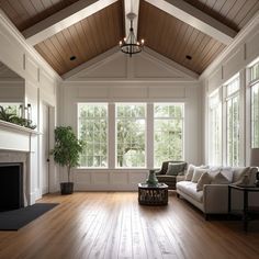 a living room filled with furniture and a fire place in front of a large window