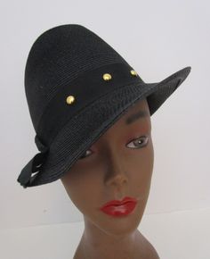 "Vintage 1950s black faux straw trilby hat.  From Juli Kay Chicago with union label. Cocky exaggerated shape with tall creased crown and asymmetrical narrow brim. Wide grosgrain band with gold stud detail.  I will leave the hat pin previous owner attached to back.  Vintage and preowned fashion is a simple sustainable way you can reuse recycle repurpose for a healthier Earth, Condition:   Very good vintage condition, slightest misshape, wear inside band, See photos. Size:  Sits up high on head. M Vintage Black Straw Hat With Curved Brim, Vintage Black Straw Hat With Short Brim, Vintage Black Brimmed Straw Hat, Classic Evening Straw Hat With Short Brim, Classic Brimmed Straw Hat For Evening, Vintage Straw Hat With Short Brim For Evening, Vintage Black Boater Hat With Curved Brim, Vintage Black Straw Hat With Flat Brim, Vintage Black Brimmed Fedora