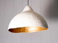 a white and gold light hanging from a ceiling