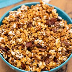 a blue bowl filled with popcorn and nuts