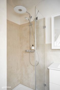 a bathroom with a shower head, mirror and bathtub next to the sink area