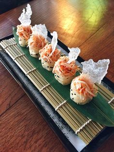 some food is sitting on top of a bamboo mat in front of a wooden table