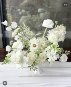 a vase filled with white flowers on top of a table