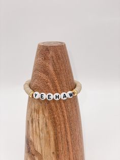 "This listing is for one \"yeehaw\" bracelet. Pictured with tan heishi beads, white with black letters, and gold spacer beads. The standard size for the bracelets is 6.75 inches. **Please measure your wrist before ordering as we do not offer returns or exchanges for resizing** You may request custom sizes in the personalization box. We can make bracelets for children as well, but please measure their wrists for the most accurate fit. Please reference the chart posted in the photos if you are uns Western Heishi Bracelet, Vsco Bracelets, Cowgirl Bracelets, Keep Bracelet, 2025 Goals, Pride Bracelet, Fun Bracelet, Acrylic Letters, Clay Bracelet