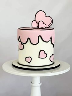 a pink and white cake with hearts on it