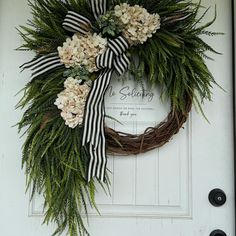 a wreath with flowers on the front door