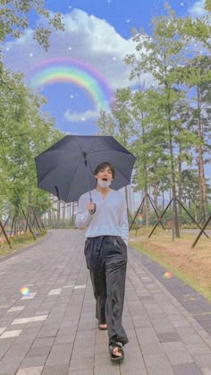 a man walking down the street with an umbrella in his hand and a rainbow in the background