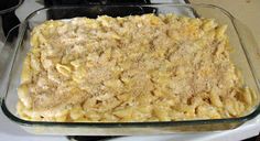 a glass casserole dish filled with macaroni and cheese on top of a stove