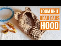 a knitted bear ears hood with measuring tape next to it