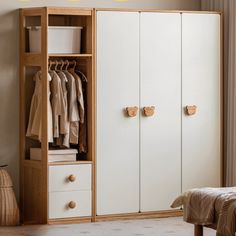 a white wardrobe with drawers and clothes hanging on the door knobs next to a bed