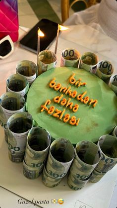 a birthday cake made out of money with candles in the middle and words written on it