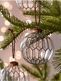 three glass ornaments hanging from a christmas tree