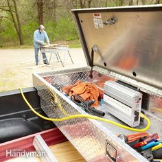 a man standing next to an open trunk filled with tools and equipment in the back of a truck